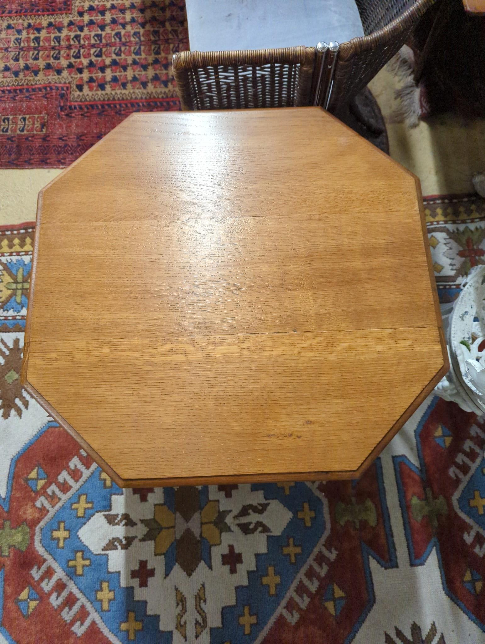 A 1930's Heals style octagonal golden oak book table, width 60cm, height 58cm